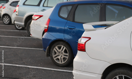Closeup of rear or back side of white car with other cars parking in parking area in twilight evening.  © Amphon