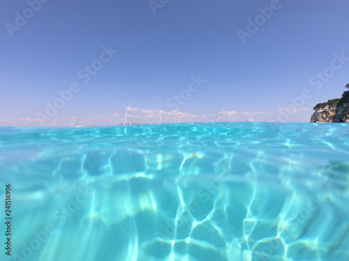 Underwater photo of mediterranean paradise island sandy beach with turquoise clear sea © aerial-drone