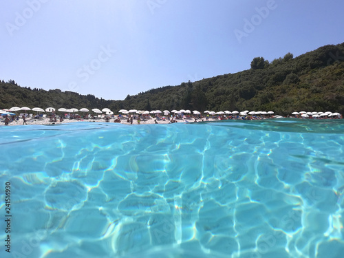 Underwater photo of mediterranean paradise island sandy beach with turquoise clear sea