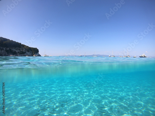 Underwater photo of mediterranean paradise island sandy beach with turquoise clear sea