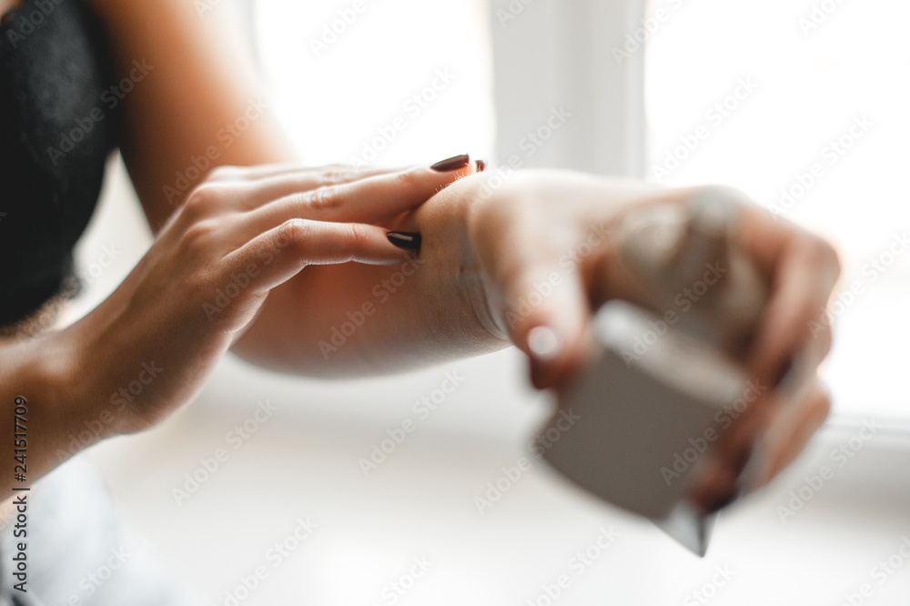 girl in underwear puts cream on her hand to moisturize the skin