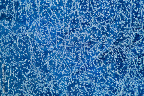 New Year and Christmas abstract icy frost cold weather snowy background with real ice crystals macro in cold blue tones