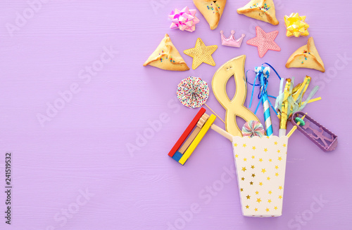 Purim celebration concept (jewish carnival holiday) over pink wooden background. Top view. Banner. © tomertu