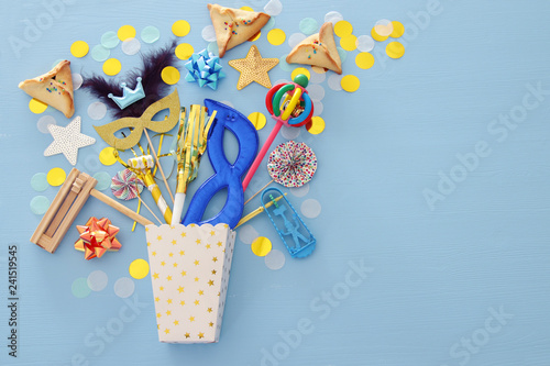 Purim celebration concept (jewish carnival holiday) over blue wooden background. Top view. Banner.