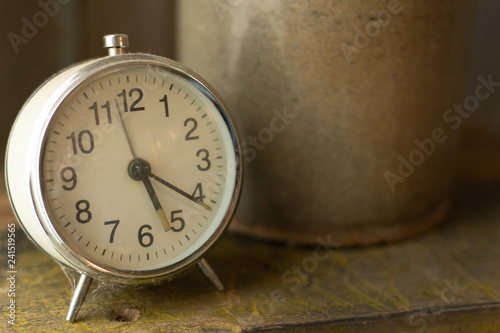 White vintage clock alarm near window light.