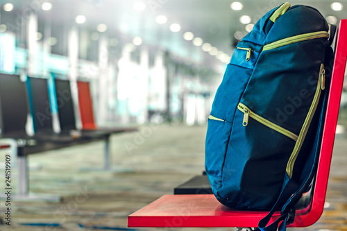 Blue backpack on seat in the interior of airport terminal. Travel concept