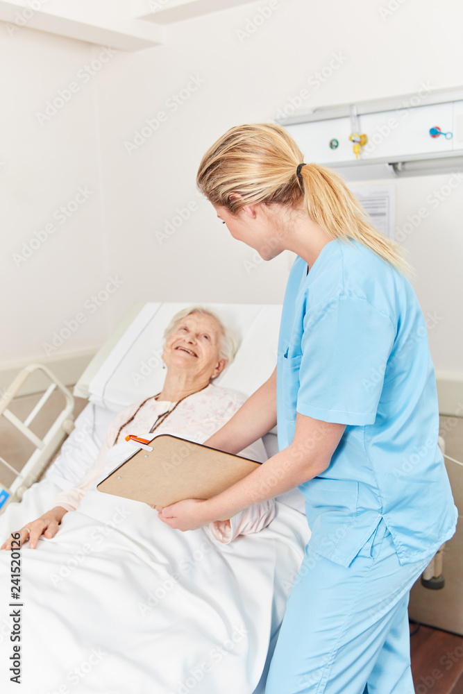 Krankenpflegerin am Bett einer Patientin Krankenpflegerin am Bett einer Patientin