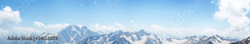 mountains peaks in the snow and clouds panoramic view