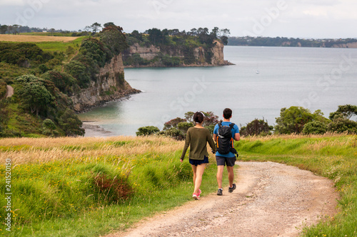 young couple walking on long bay beach