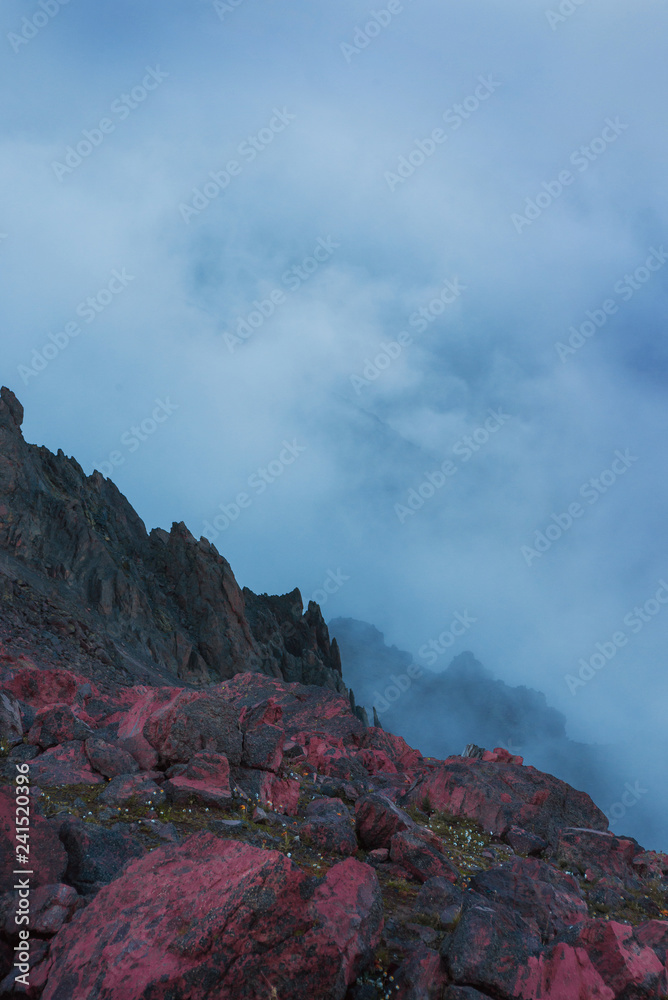 Mistic evening foggy landscape of wild nature in the mountains. Red stones. alien landscape
