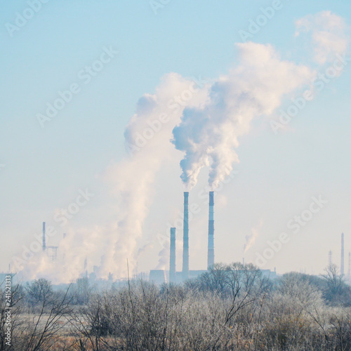 Modern landscape with factory pipes at a distance from which smoke is polluting the air