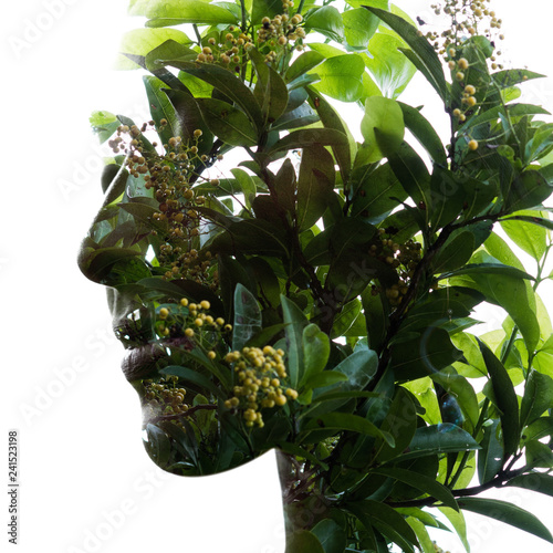 Double exposure of a young natural beauty's profile portrait combined with tropical leaves and small yellow flowers