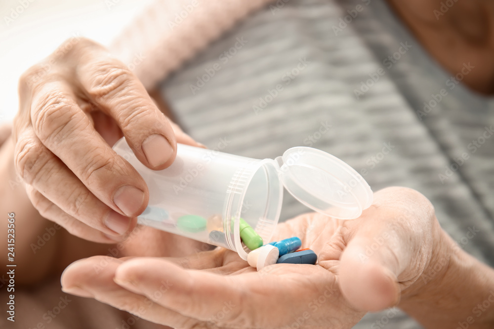 Elderly woman holding container and different pills, closeup Elderly woman holding container and different pills, closeup