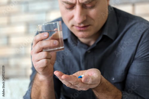 Mature man taking pill at home