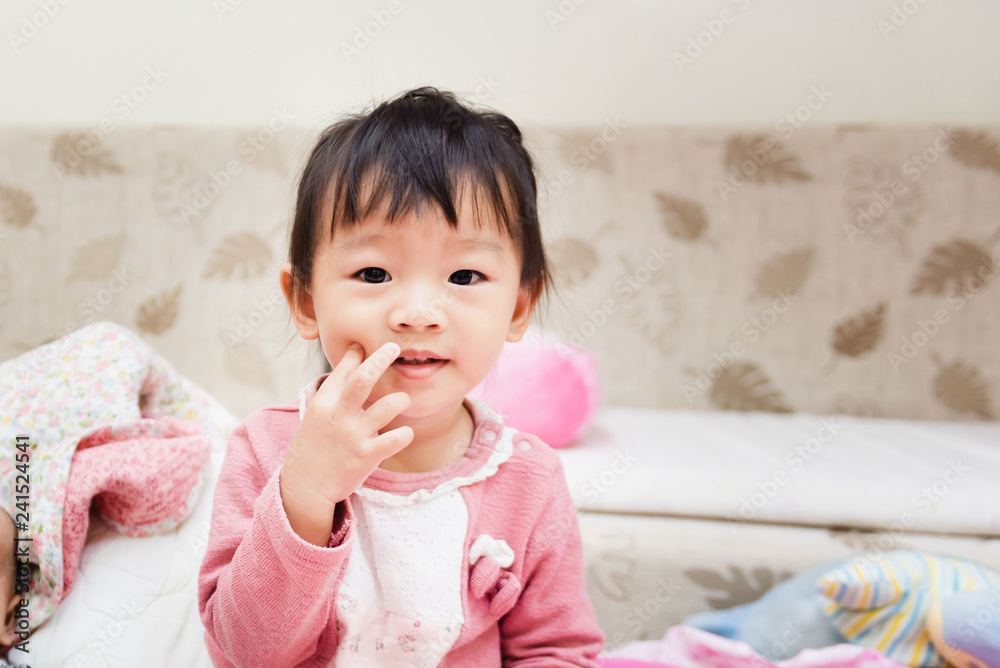 Closeup of happy little child smiling after wake up and playing over the bed in a relaxed morning Closeup of happy little child smiling after wake up and playing over the bed in a relaxed morning
