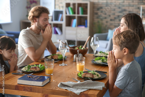 Family praying before meal ...
