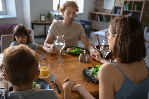 Family praying before meal ...
