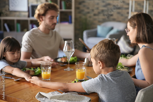 Family praying before meal ...