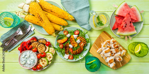 Summer bbq party concept - grilled chicken, vegetables, corn, salad, top view, copy space © anaumenko