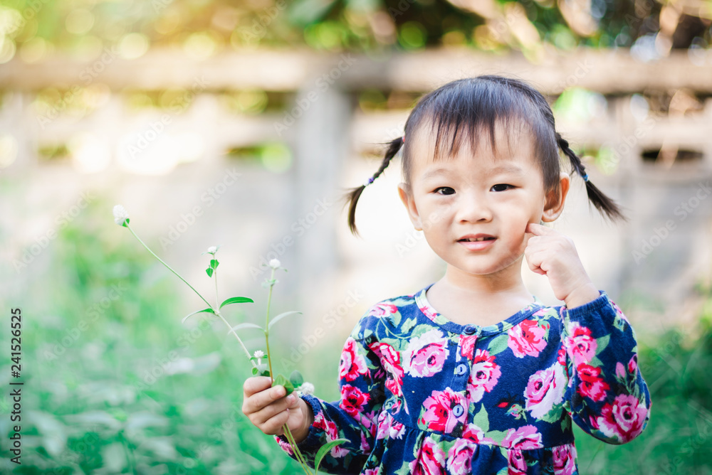 Adorable Asian Girl enjoy with grass and flower in garden outdoor Adorable Asian Girl enjoy with grass and flower in garden outdoor