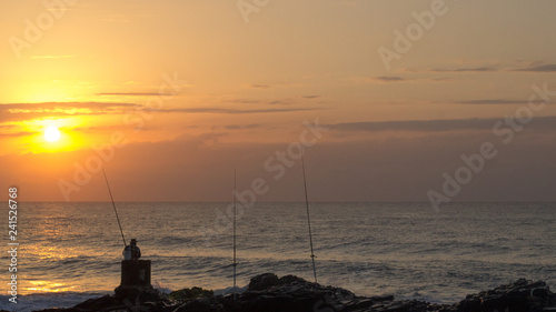 silhouette of fisherman at sunrise over the indian ocean 
