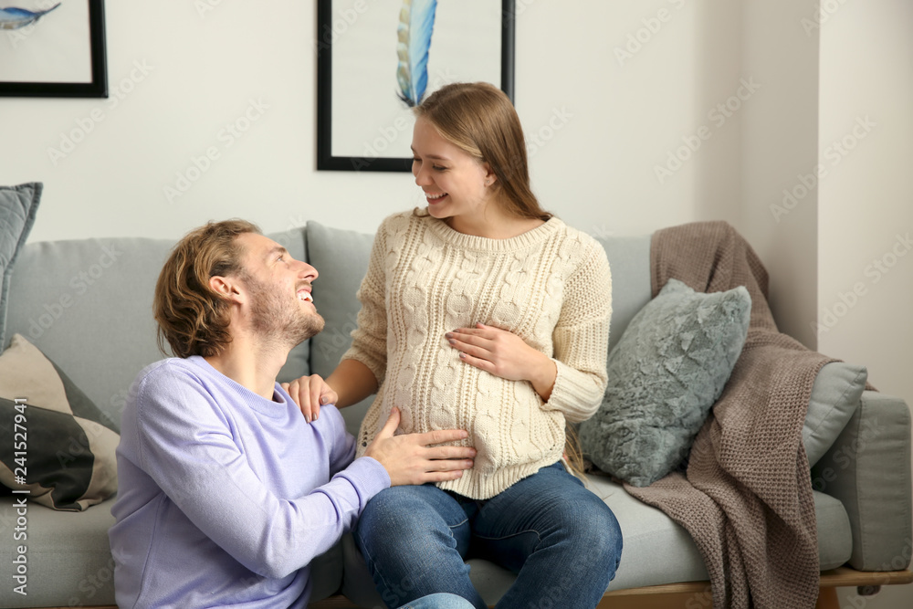 Young pregnant woman with her husband at home