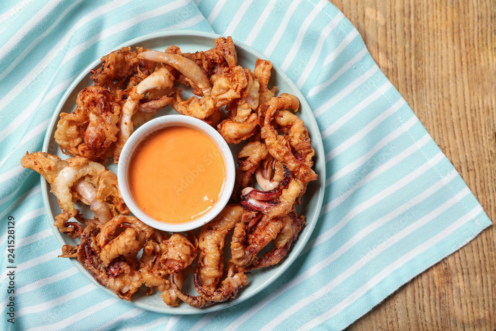 Tasty fried squid with sauce on table Tasty fried squid with sauce on table