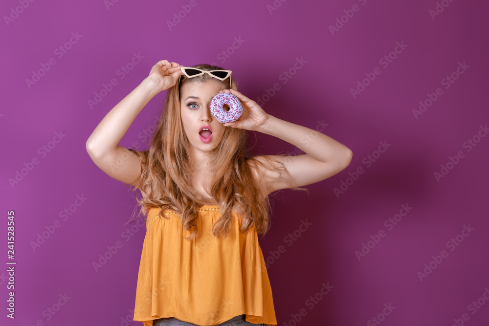Funny young woman with tasty donut on color background Funny young woman with tasty donut on color background