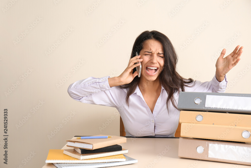 Screaming young woman sitting at table in office Screaming young woman sitting at table in office