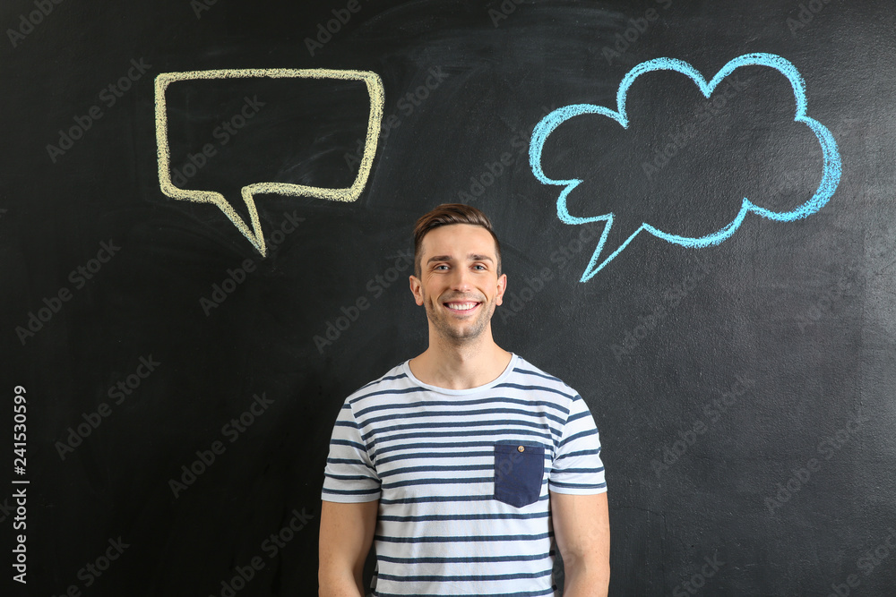Young man and blank speech bubbles drawn on dark background