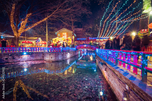 Fototapeta Naklejka Na Ścianę i Meble -  Night view of the greek Christmas market “Oneiroupoli” with lights, figurines around the river in Drama, Greece