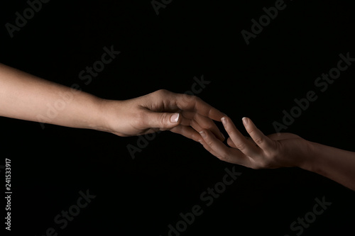 Female hands touching fingers on dark background