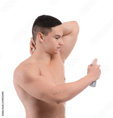 Young man using deodorant on white background