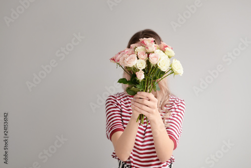 Fototapeta Naklejka Na Ścianę i Meble -  Beautiful young woman with bouquet of flowers on grey background