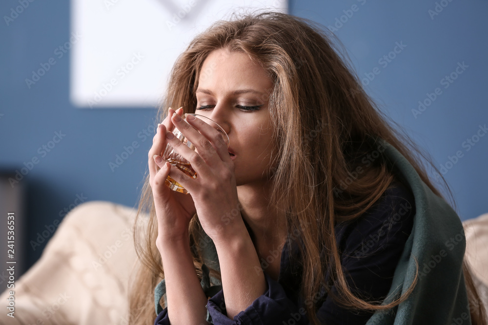 Depressed woman drinking alcohol at home Depressed woman drinking alcohol at home