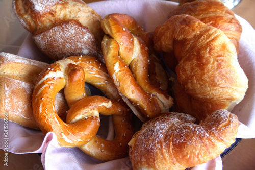 Frühstückskorb mit Croissants, Brezen und Brötchen photo