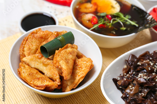 Tasty Chinese dumplings in bowl on table