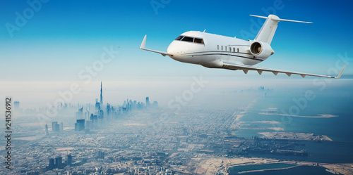 Private jet plane flying above Dubai city