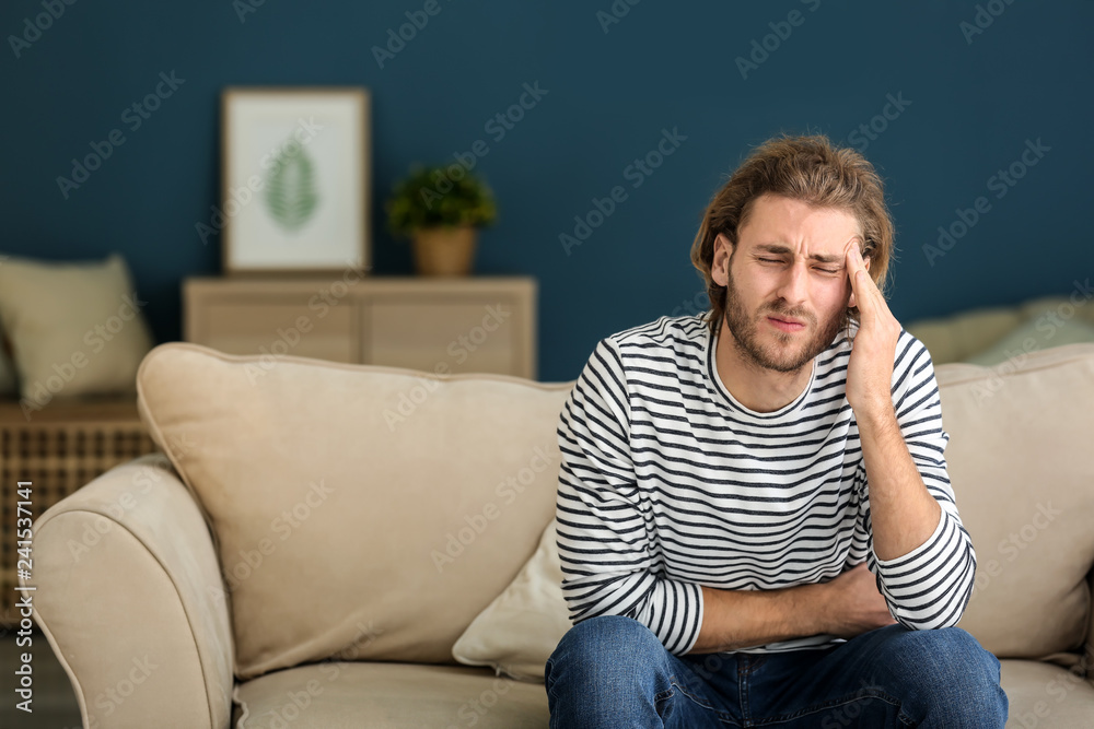 Young man suffering from headache at home Young man suffering from headache at home