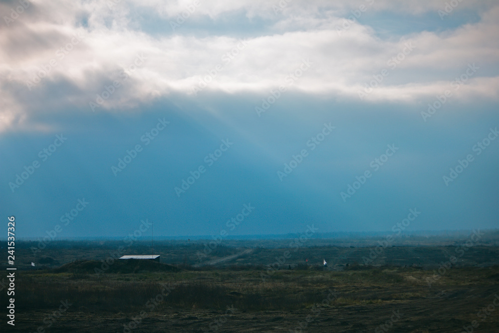 Rain clouds and sunrays. Rural landscape. Horizon.