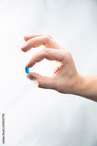 Żelowa tabletka. Mężczyzna trzyma w dłoni tabletkę