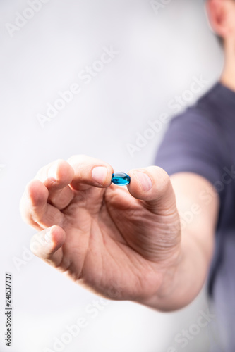 Tabletka. Mężczyzna trzyma w dłoni tabletkę