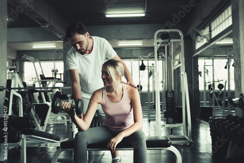 Beautiful sexy woman in fitness gym training with fitness equipment in sport gym and many bodybuilding, Lifting weight loss ,Portrait couple people exercise body gym Sporty and healthcare concept.