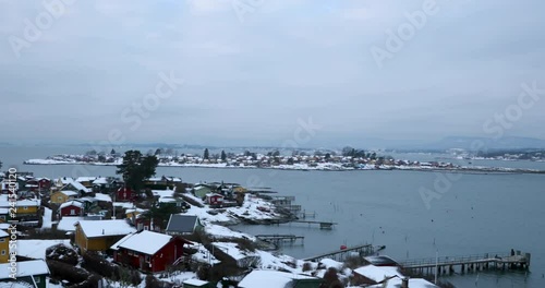 Panoramic shot of ostra near Oslo in Norway with a view of the sea and beautiful local houses during winter covered with snow.