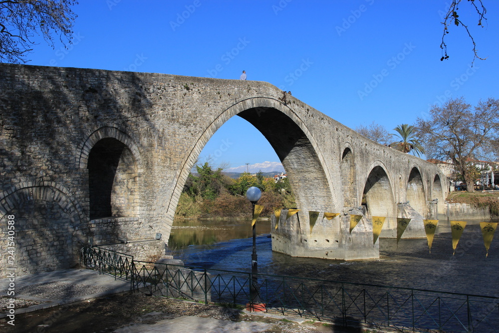 Old famous stone bridge at the city of Arta at the banks of Arachthos river in Epirus Greece