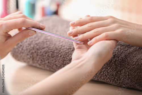 Fototapeta Young woman getting beautiful manicure in salon