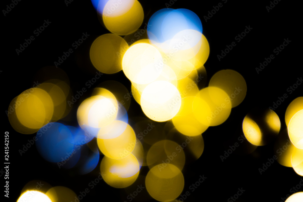 Fototapeta premium Abstract blurred yellow circles on dark background.