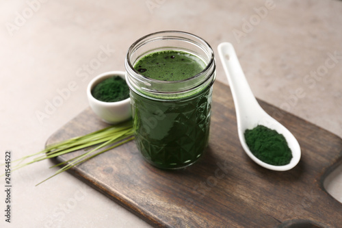 Glass with spirulina drink on table