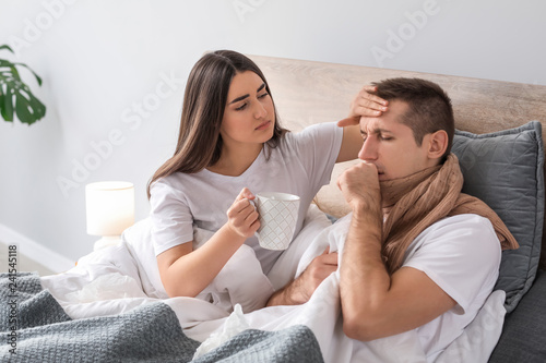 Woman taking care of her husband ill with flu at home