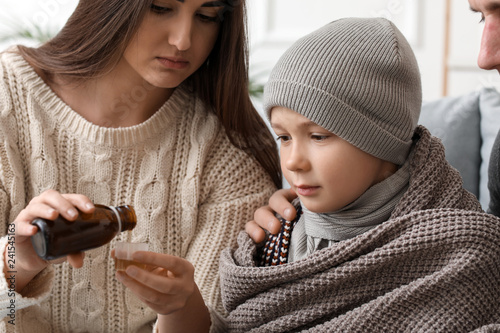 Mother giving medicine to h...